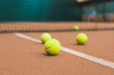 green-tennis-balls-court-near-net-scaled-e1608657962135